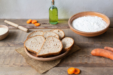 Homemade carrot bread with bran and ingredients. Healthy nutrition concept. Rustic style. Horizontal orientation.