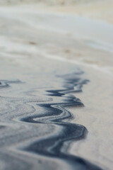 stripe of black sand amid clear sand