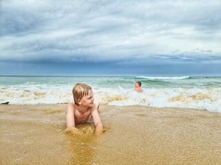 Fototapeta na wymiar Children playing in rough surf at the beach on the east coast of Australia