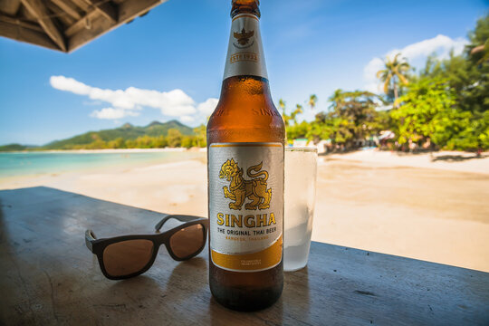 Sunny beach and popular asian beer bottle Singha in local bar in Thailand.
