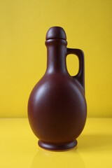 brown bottle ceramic flask on yellow trend color background