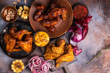Crispy barbecue chicken wings with onion. Food background. Hot and spicy bbq chicken wings.