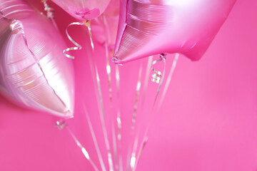 Pink balloons with helium on a pink background
