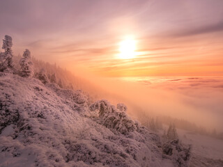 Scenic landscape with a view from a mounatin range to the valley filled with low clouds and fog...