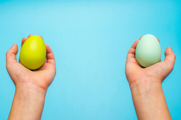 Hands holding painted easter eggs. Easter eggs in a childs hands on a blue background