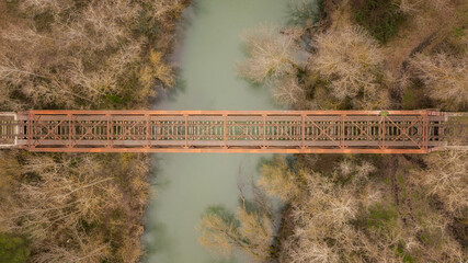aerial view to old rusted train bridge over a river