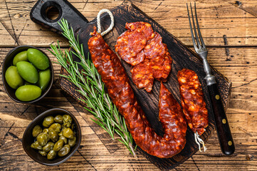 Spanish traditional tapas Sliced chorizo salami, chorizo sausage. wooden background. Top view - obrazy, fototapety, plakaty