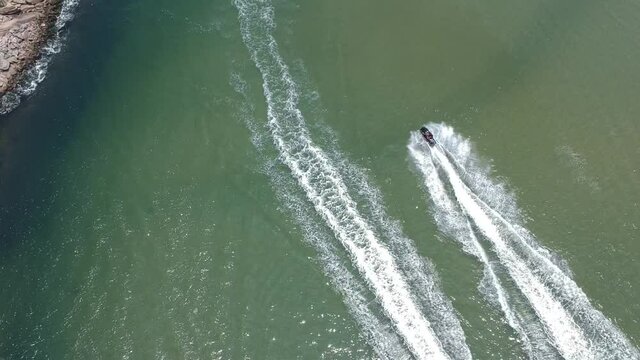 Aerial drone image of Barra da Tijuca beach in Rio de Janeiro while people ride a jet ski