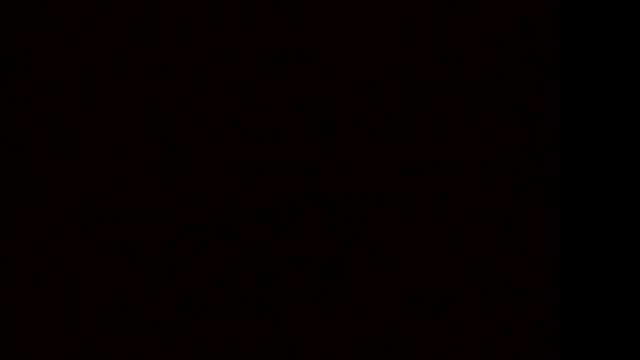 A yellow slow motion spark rising on a Jacob&rsquo;s Ladder in the dark. Only the spark is visible, the rest of the scene is black.