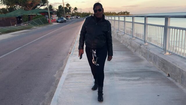 Old Bahama Mama OBM at Sea wall in Black Outfit. Freeport, Bahamas  
