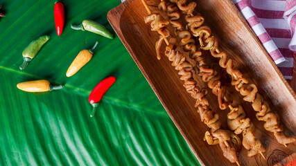 Chicken Satay or Sate Ayam - Indonesian famous food. Is a dish of seasoned, skewered and grilled meat - served on wooden plate