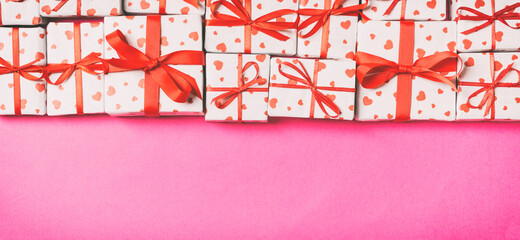 Holiday composition of gift boxes with red hearts on colorful background with empty space for your design. Top view of Valentine's Day concept