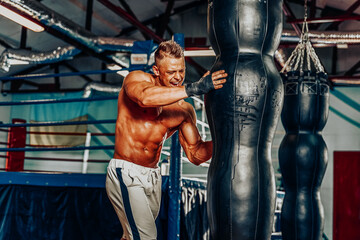 Fototapeta na wymiar Boxer training on a punching bag in the gym.