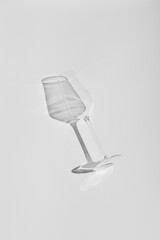 Champagne glass on white surface. Glass with shadow on white table.