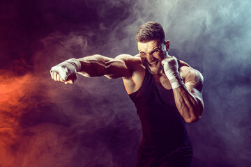 Fototapeta na wymiar Sportsman boxer fighting on black background with shadow. Copy Space. Boxing sport concept. Smoke on background