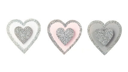 three hearts of different colors covered with sequins stand in a row on a white isolated background