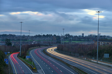 Fototapeta na wymiar Beautiful very long exposure evening view of light trails of vehicles on motorway M50 Dublin, Ireland. Transportation during Level 5 in Dublin