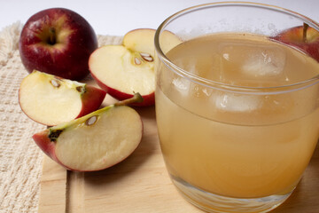 Naklejka na ściany i meble Natural apple juice in glass cup, with pieces of apple around