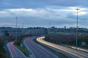 Fototapeta na wymiar Beautiful very long exposure evening view of light trails of vehicles on motorway M50 Dublin, Ireland. Transportation during Level 5 in Dublin