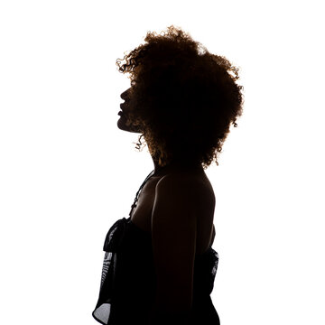 Shaded silhouette of a young African woman against a white background. The woman is standing sideways and you can see her profile.