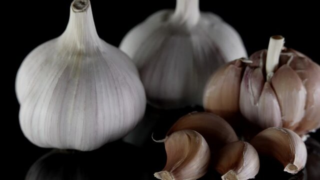 heads of garlic on black table, spices for cooking, closeup view