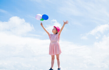 international childrens day. happy childhood. little child with balloons. Entertainment birthday concept. freedom. child having party and dancing with balloons in hands. kid having fun