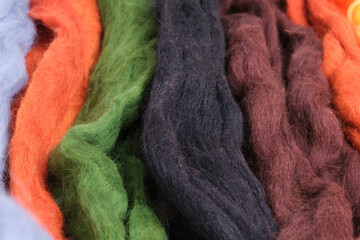 wool of different colors and textures. Background made of wool felting in the form of lines.