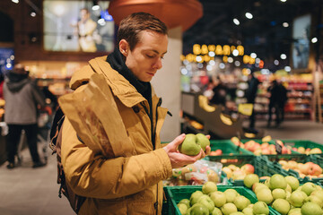 Man chooses apple in a supermarket