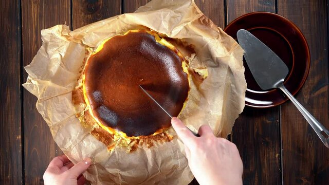 Cutting basque burnt cheesecake and serving it on a plate