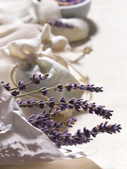 Hand made lavender sachets in textile bags and cotton hearts on cotton background. Low impact natural lifestyle. Bunch of dry lavender, close-up. Dry lavender flowers in wrapping paper.