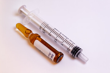 Syringe and a medication vial on a white background