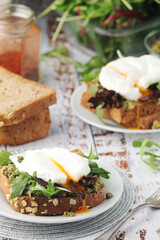 Homemade sandwiches with pesto, green salad and poached eggs
