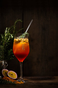 Spritz cocktail with passion fruit, orange and rosemary with ray of light