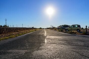 Punto de vista desde del el suelo de carretera asfaltada con sol a contraluz