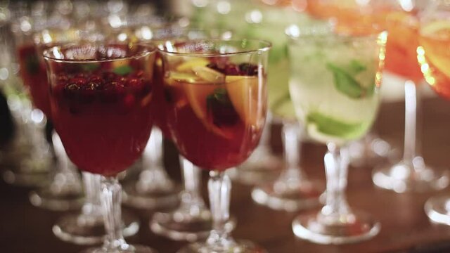 View of alcohol setting on catering banquet table, row line of different colored alcohol cocktails on party, martini, vodka, spritz and others on decorated catering table event