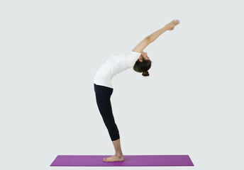 Young woman making yoga triangle pose on mat on white background
