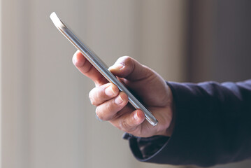 Close up young man hand holding using smartphone