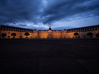 Panorama of yellow stone Schloss Karlsruhe Castle Palace Schlosspark at night in Baden Wurttemberg...