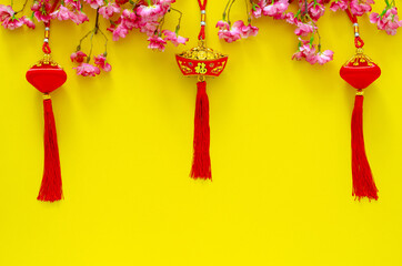 Hanging pendants for Chinese new year ornament (meaning of word is wealth) with Chinese blossom flowers on yellow background.