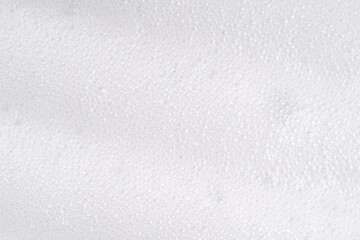 White foamy cleansing skin care product texture from soap, detergent, shampoo, shaving foam or cleanser. Soapy surface closeup. Foam macro background with bubbles. Beer drink backdrop, laundry spume