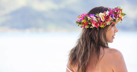 Woman wearing colorful flower crown on vacation at beautiful tropical island Bora Bora in French Polynesia