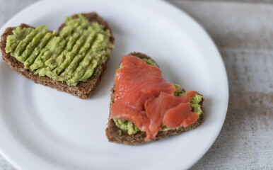Sandwich with avocado paste and salmon in the shape of heart