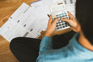 Top view man sitting on the floor stressed and confused by calculate expense from invoice or bill,...