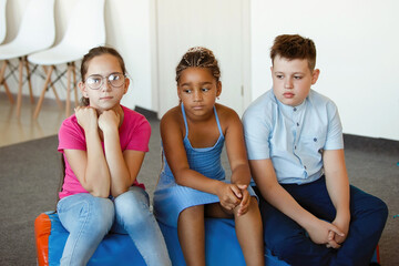 Three teenagers sit and are sad.