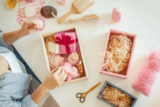 Young Woman Placing Handmade Organic Bath Supplies Into Bridesmaid Gift Box Set.