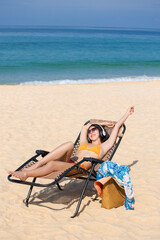 Fototapeta na wymiar Asian woman are sitting on the beach While relaxing on vacation for the weekend on sunny days and nice weather in travel and holiday concept.
