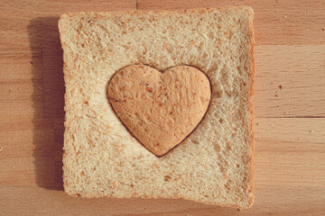 Grained bread cut off as heart shape. Concept of love and care in Valentine day.