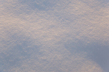 winter background: snowy field, lit by the setting sun, late evening