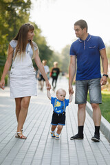 Family mom, dad, son walking on sidewalk