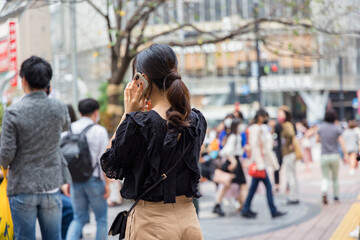 渋谷駅前で電話をする若い女性